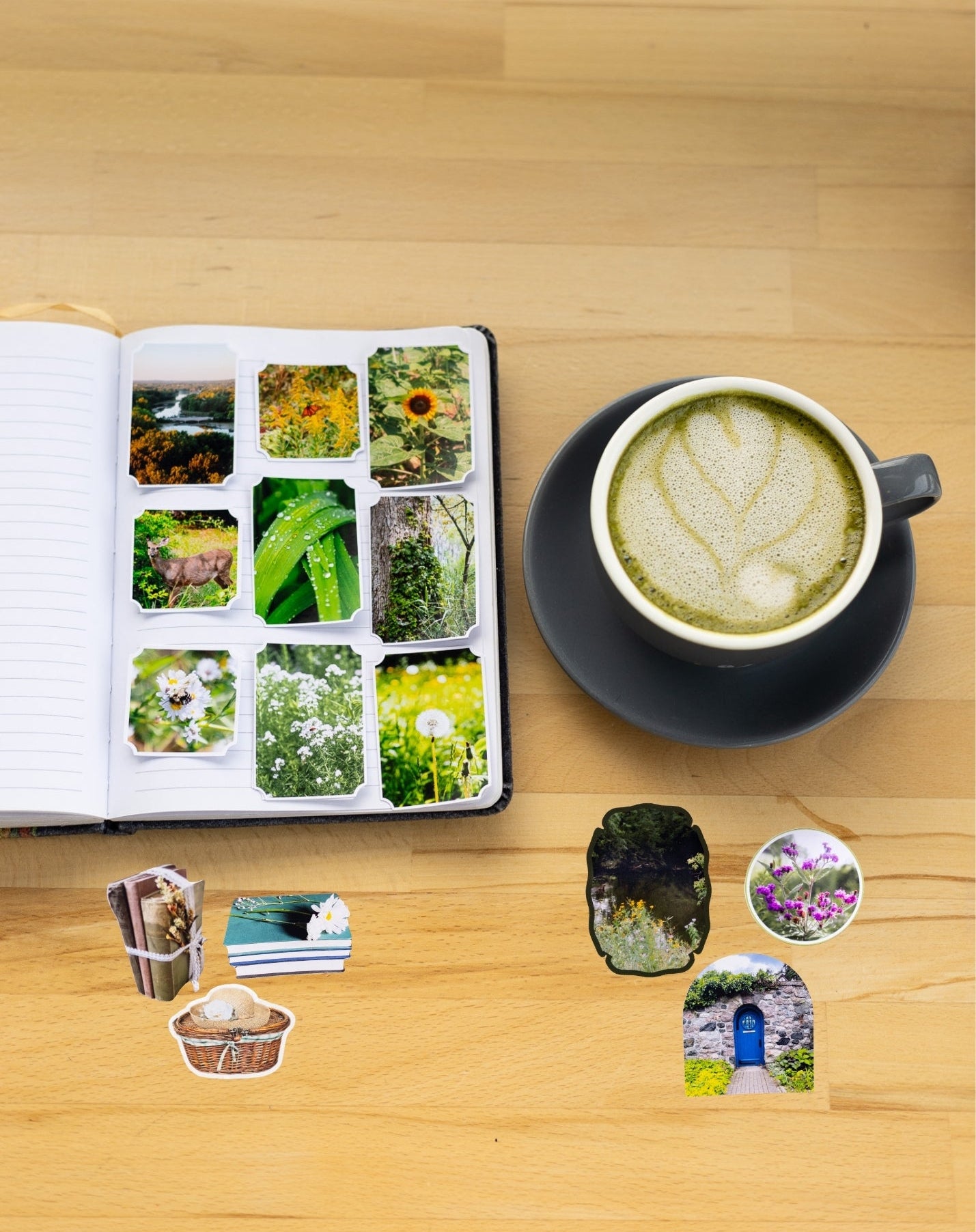 Open book with nature-themed stickers, a cup of green tea on a wooden table.